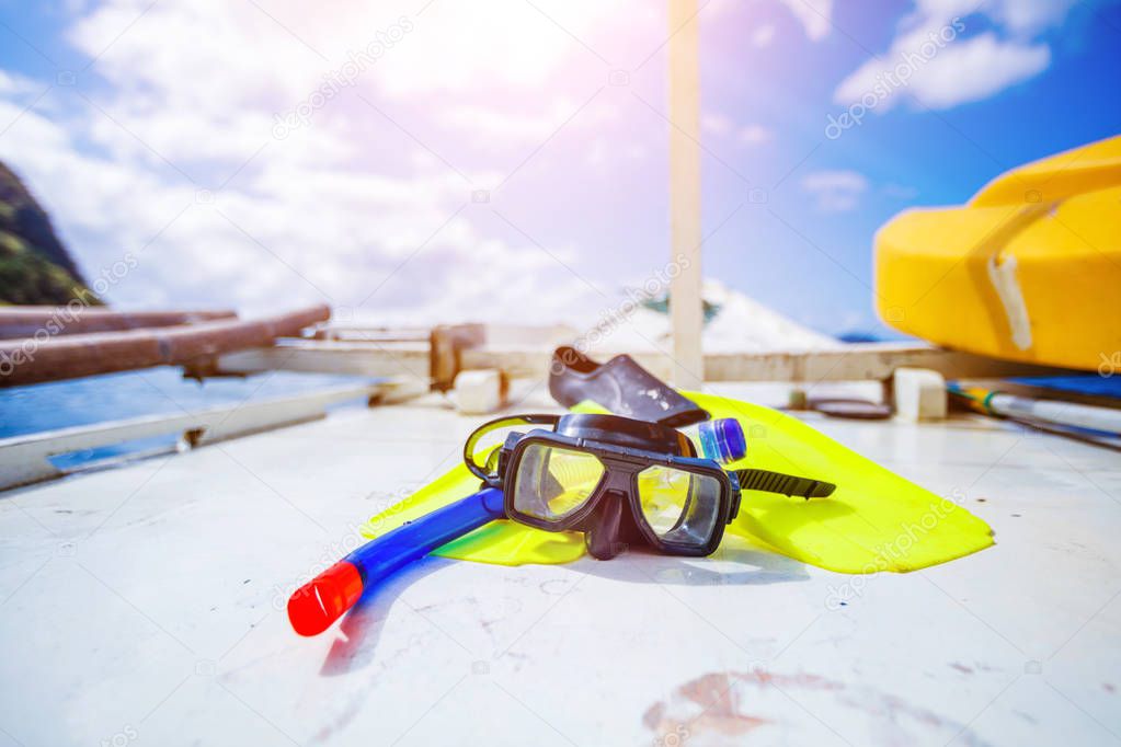 Scuba diving and snorkeling equipment on wood background. The deck and the ships bow