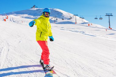 Kız snowboardcu kış kayak merkezinde eğleniyor..