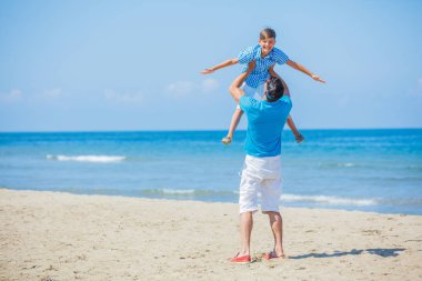 Baba ve oğul birlikte kumsalda oynarken.