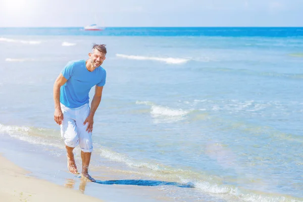 Aantrekkelijke jonge man op een tropisch strand — Stockfoto