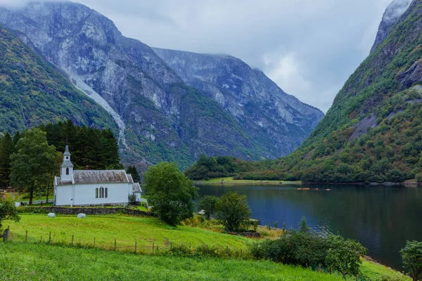 Igreja com um cemitério fica na margem do fiorde, Noruega — Fotografia de Stock