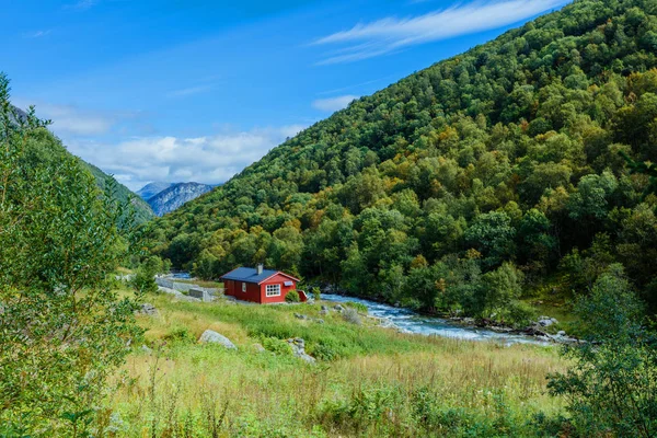 Typická krajina norská krajina s červeně natřené zdi domu. Ráno zataženo léto v Norsku, Evropa. — Stock fotografie