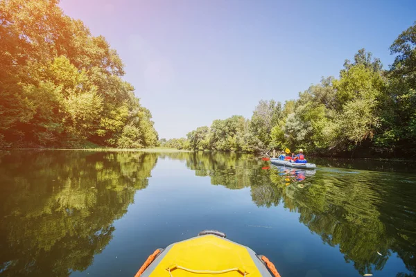 Gelukkige kinderen kajakken op de rivier op een zonnige dag tijdens de zomervakantie — Stockfoto