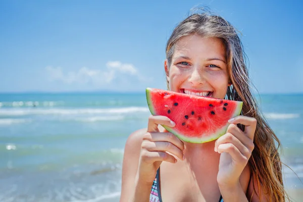 Porträt eines schönen Mädchens mit Wassermelone am Strand. — Stockfoto