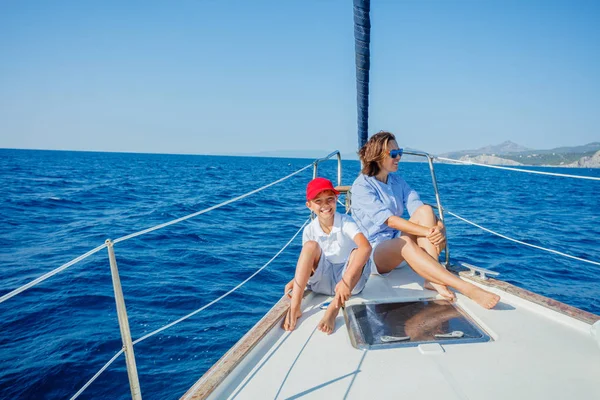 Boy with his mother on board of sailing yacht on summer cruise. — Stock Photo, Image