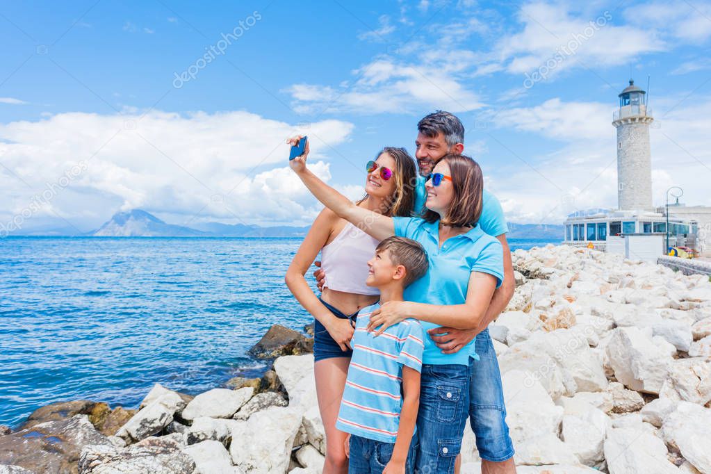 Happy family making selfie in front of Patras lighthouse, Peloponnese, Greece.