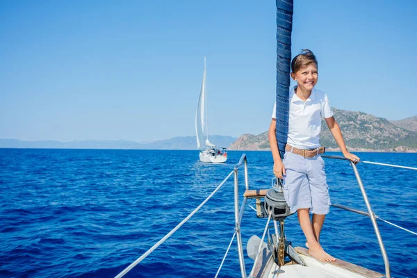 Niño a bordo de un yate de vela en un crucero de verano. Aventura de viaje, yates con niños en vacaciones en familia. — Foto de Stock