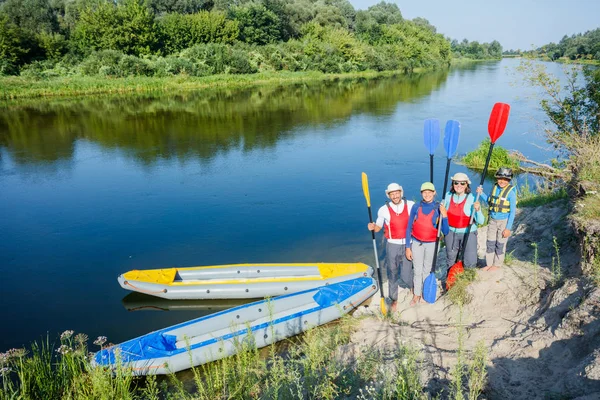 Famiglia felice con due bambini che si godono un giro in kayak sul bellissimo fiume. Ragazzino e adolescente kayak in calda giornata estiva. Sport acquatici divertimento . — Foto Stock