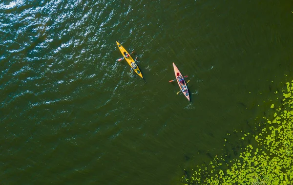 Luchtfoto drone vogels eye foto weergeven van gelukkige familie met twee kinderen genieten van de kajak rit op de prachtige rivier. Jongen en tiener meisje kajakken op een warme zomerdag. Water sport plezier. — Stockfoto