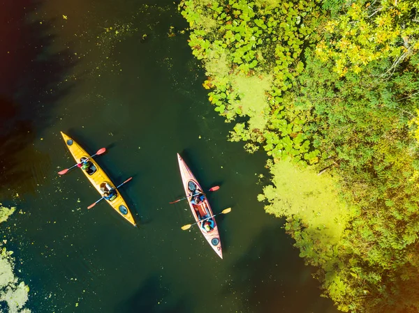 Aerial drone birds eye view photo of Happy family with two kids enjoying kayak ride on beautiful river. Little boy and teenager girl kayaking on hot summer day. Water sport fun. — Stock Photo, Image