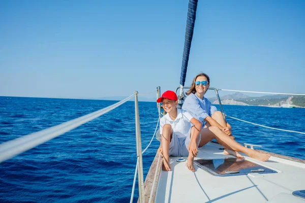 Boy with his mother on board of sailing yacht on summer cruise. — Stock Photo, Image