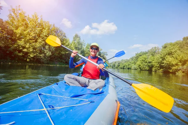 Una chica feliz en un Kayak. Niña remando en kayak en el agua del río en el soleado día de verano . — Foto de Stock