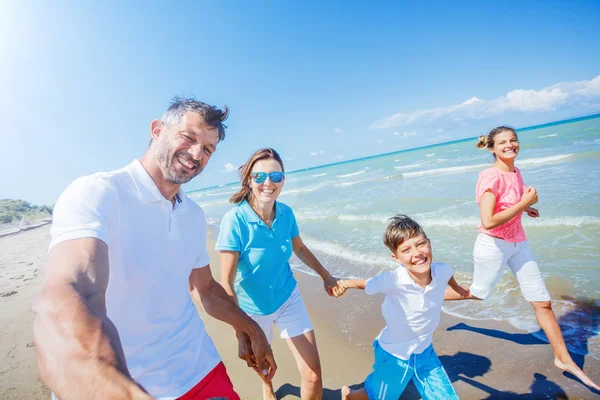 Familia feliz divirtiéndose en la playa juntos. Divertido estilo de vida feliz en el ocio de verano —  Fotos de Stock