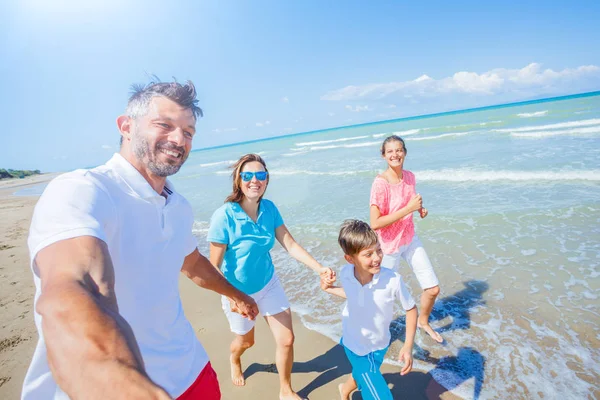 Família feliz se divertindo na praia juntos. Divertido estilo de vida feliz no lazer de verão — Fotografia de Stock