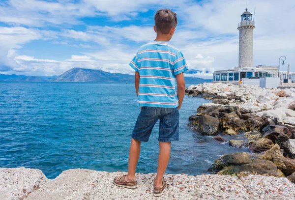 Garçon regardant le phare de Patras, Péloponnèse, Grèce . — Photo