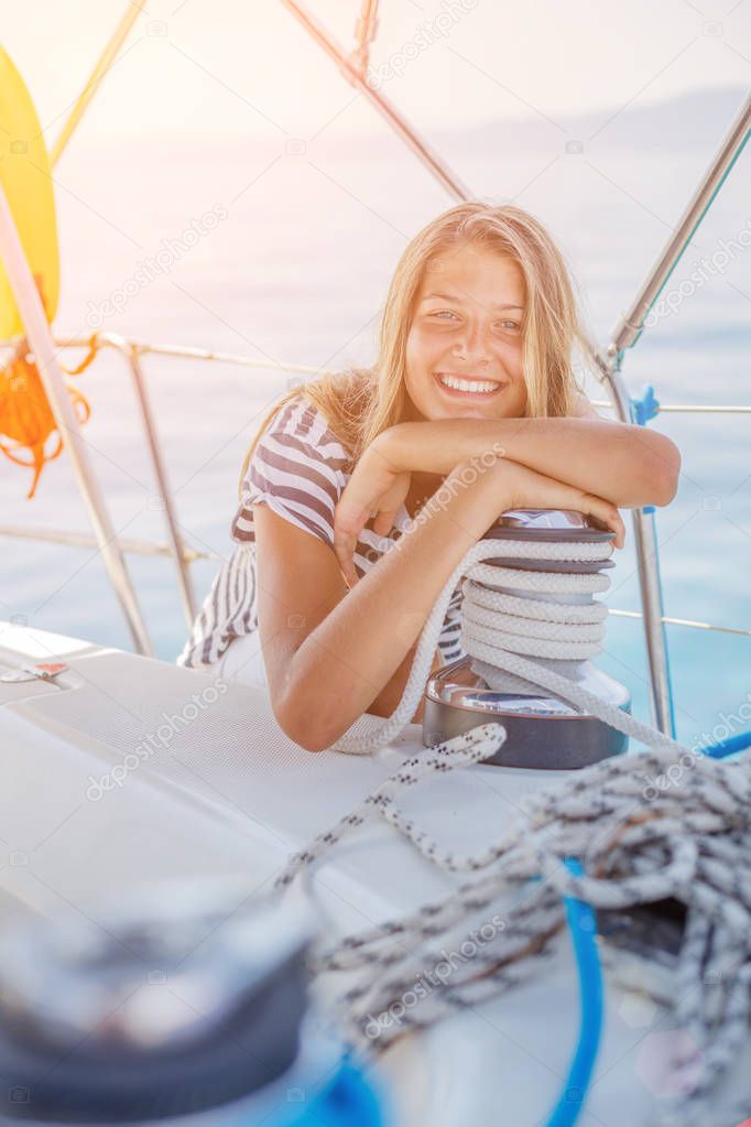 Girl on board of sailing yacht on summer cruise. Travel adventure, yachting with child on family vacation.