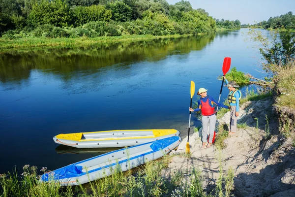 Two kids enjoying kayak ride on beautiful river. Little boy and teenager girl kayaking on hot summer day. Water sport fun. — Stock Photo, Image