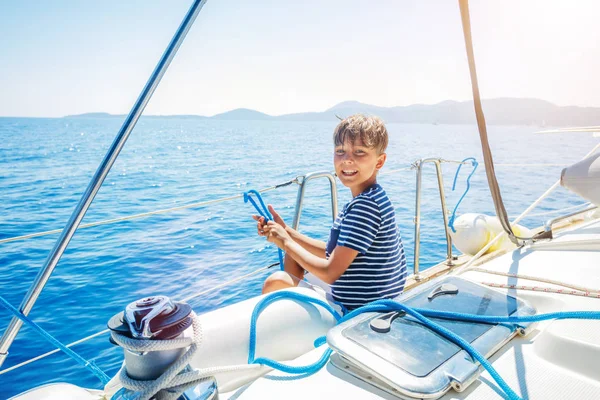Küçük çocuk yaz gezisinde yelkenli yatında. Seyahat macerası, çocuğuyla yat gezisi..