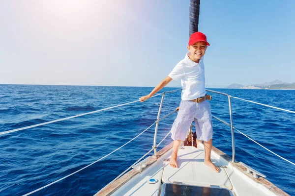 Kleine jongen aan boord van zeiljacht op zomercruise. Reis avontuur, zeilen met kind op vakantie met het gezin. — Stockfoto