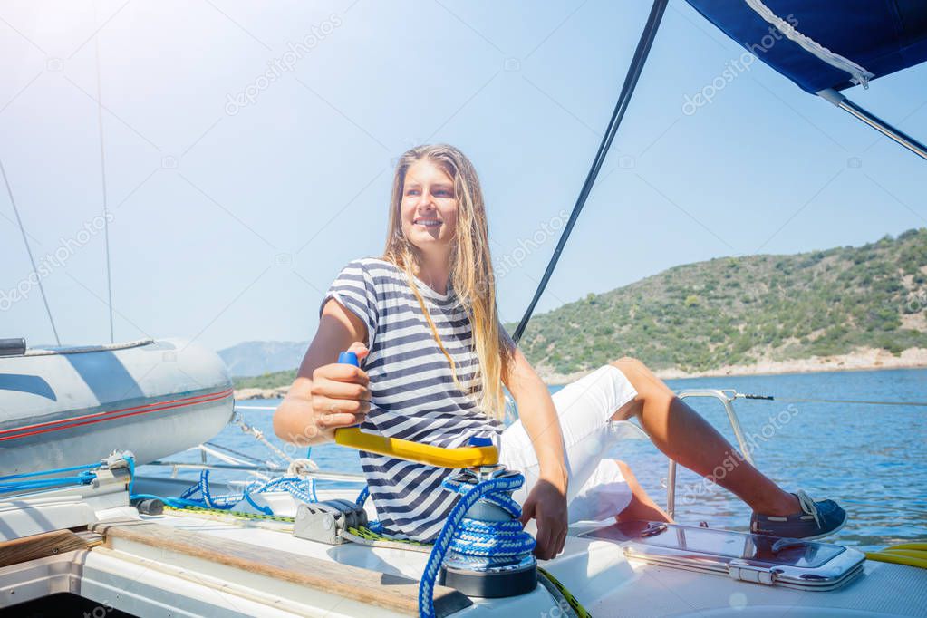 Girl on board of sailing yacht on summer cruise. Travel adventure, yachting with child on family vacation.