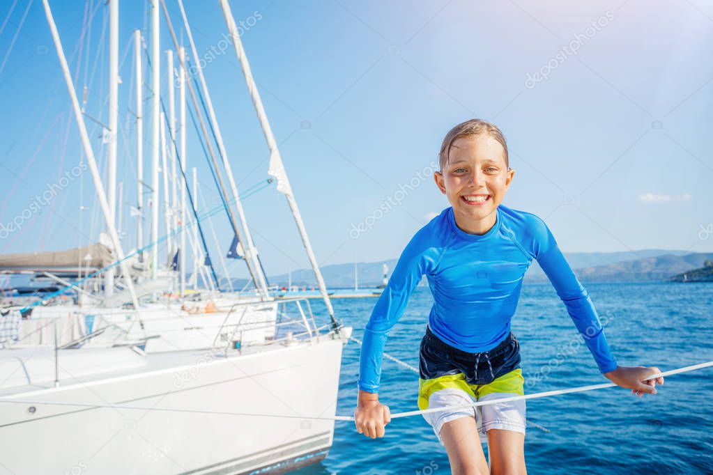 Little boy having fun on board of yacht on summer cruise. Travel adventure, yachting with child on family vacation.
