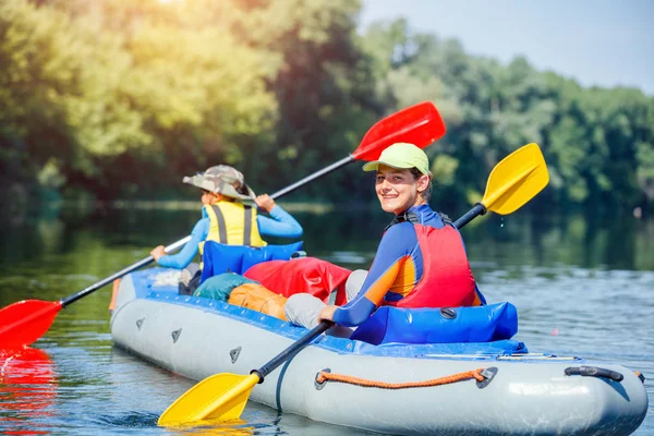 Niños felices haciendo kayak en el río en un día soleado durante las vacaciones de verano —  Fotos de Stock