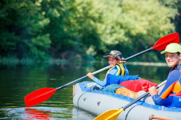 Enfants heureux kayak sur la rivière par une journée ensoleillée pendant les vacances d'été — Photo