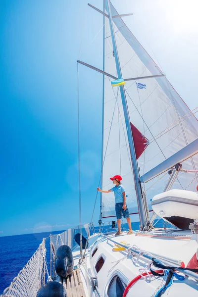 Menino a bordo do iate à vela no cruzeiro de verão. Viagem aventura, iatismo com criança em férias em família. — Fotografia de Stock