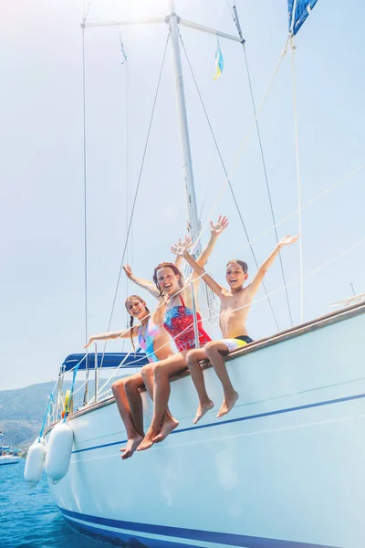 Семья с очаровательными детьми отдыхает на яхте — стоковое фото