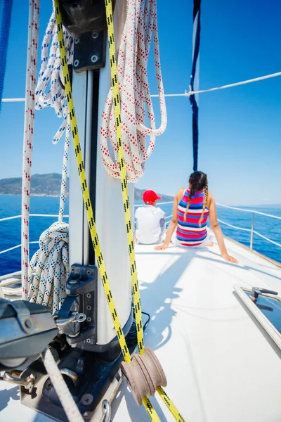 Menino com sua irmã a bordo do iate à vela em cruzeiro de verão. — Fotografia de Stock