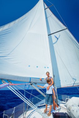 Oğlan ve kız kardeşi yaz gezisinde yelkenli teknesinde..