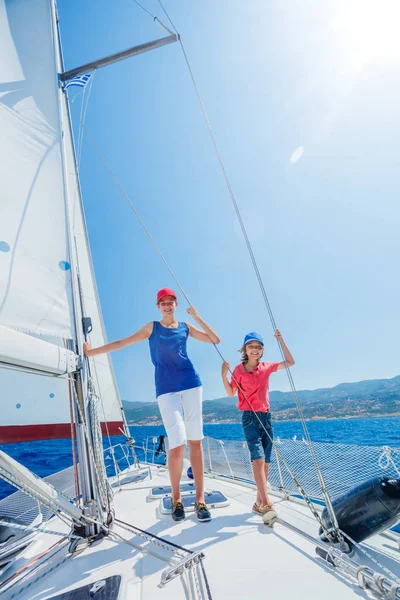 Pojke med sin syster ombord på segelbåt på sommaren kryssning. — Stockfoto