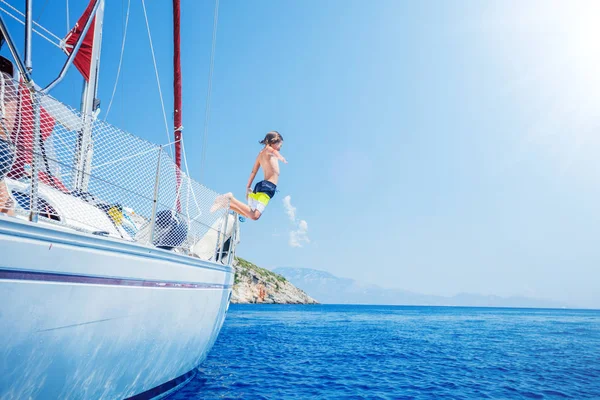 Chłopiec rejs skok w morzu jachtu na lato. Przygoda podróży, żeglarstwo z dzieckiem na wakacjach. — Zdjęcie stockowe