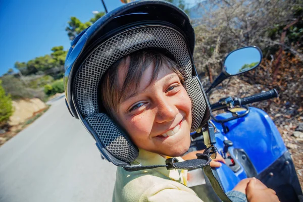 Rapaz a andar de bicicleta quádrupla. Criança gira no quadriciclo. Motor cross sports na ilha da Grécia. Crianças atividade de férias de verão . — Fotografia de Stock