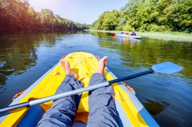 Erkek çocuklarla güneşli bir yaz tatili sırasında nehir kanosu