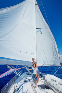 Oğlan ve kız kardeşi yaz gezisinde yelkenli teknesinde..