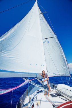 Oğlan ve kız kardeşi yaz gezisinde yelkenli teknesinde..