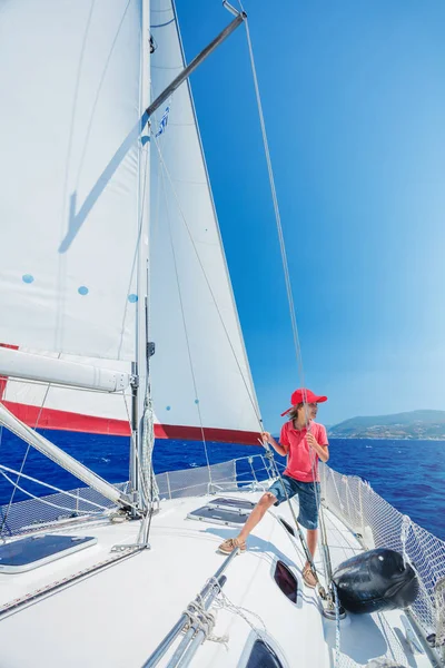 Little boy on board of sailing yacht on summer cruise. Travel adventure, yachting with child on family vacation. Royalty Free Stock Photos