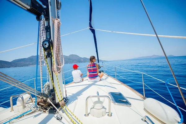 Visão traseira do menino e da menina a bordo do iate à vela no cruzeiro de verão . — Fotografia de Stock