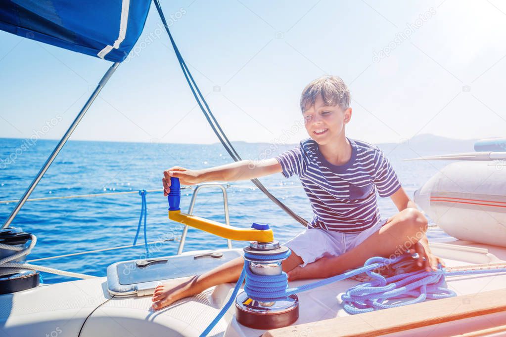 Little boy on board of sailing yacht on summer cruise. Travel adventure, yachting with child on family vacation.