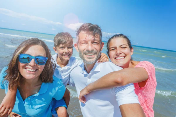 Familia feliz divirtiéndose en la playa juntos. Divertido estilo de vida feliz en el ocio de verano — Foto de Stock
