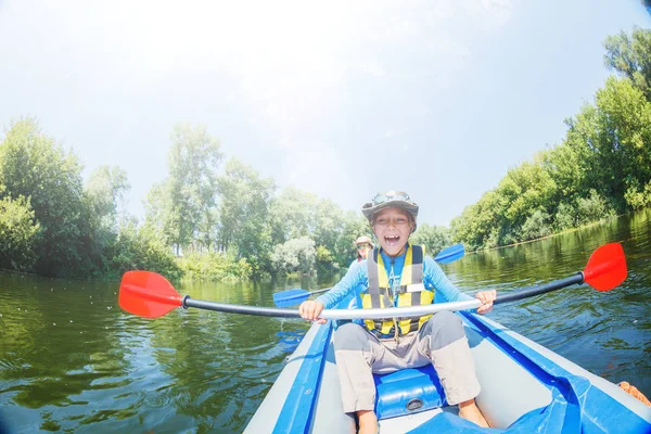 Mutlu çocuk yaz tatilinde güneşli bir günde nehirde kano yapıyor. — Stok fotoğraf