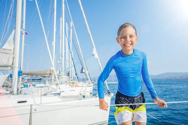 Niño divirtiéndose a bordo del yate en crucero de verano. Aventura de viaje, yates con niños en vacaciones en familia . — Foto de Stock