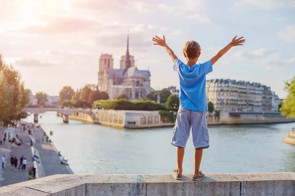 Schattige jongen kijken naar de Notre Dame de Paris kathedraal in Parijs, Frankrijk — Stockfoto