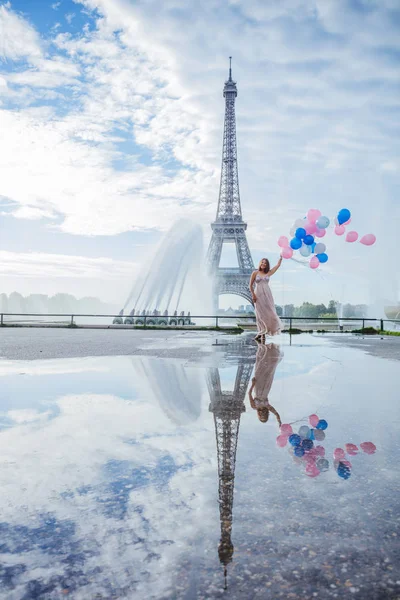 Ονειρεμένο ταξίδι-νεαρή γυναίκα με μπαλόνια με τα πόδια κοντά στον πύργο του Άιφελ στο Παρίσι — Φωτογραφία Αρχείου