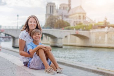 Mutlu anne ve oğlu Paris'te Notre-Dame katedrali yakınında eğleniyor. Fransa'da tatilintadını çıkaran turistler.
