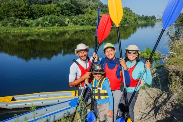 Famiglia felice con due bambini che si godono un giro in kayak sul bellissimo fiume. Ragazzino e adolescente kayak in calda giornata estiva. Sport acquatici divertimento . — Foto Stock
