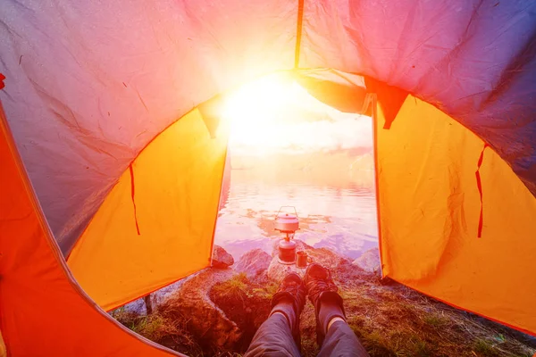 Utsikt från turist tältet till fjällen. Killen ligger i stövlar — Stockfoto