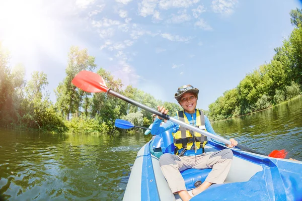 Gelukkige kinderen kajakken op de rivier op een zonnige dag tijdens de zomervakantie — Stockfoto