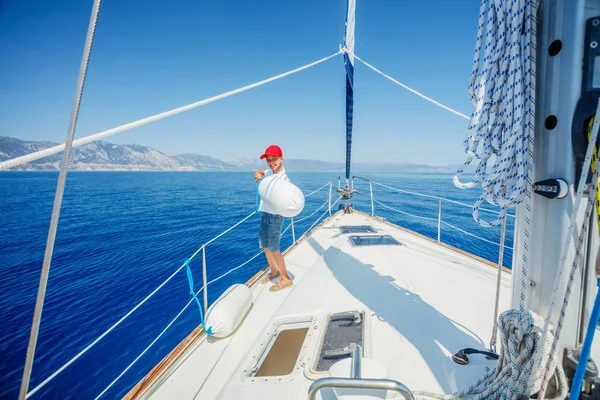 Menino a bordo do iate à vela no cruzeiro de verão. Viagem aventura, iatismo com criança em férias em família. — Fotografia de Stock